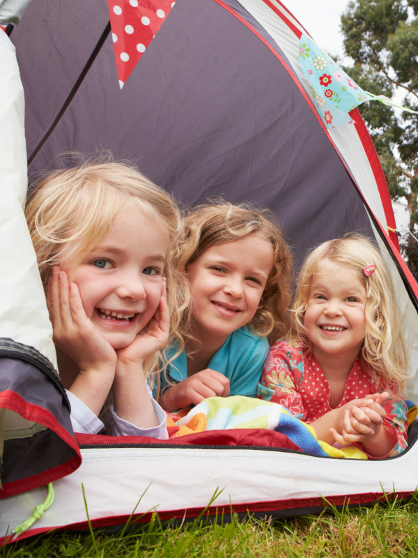 Kinder schauen aus dem Eingang eines Zeltes heraus